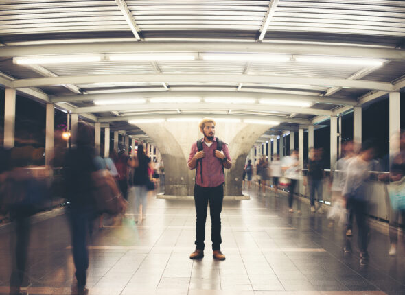 Handsome bearded man with backpack standing on the street travel